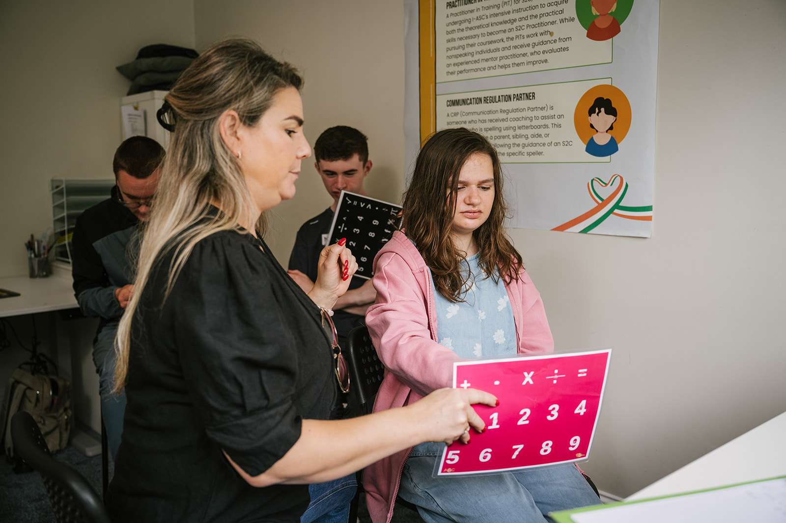 Young speller communicating on a letterboard with support from a communication partner at a Spelling Alliance of Ireland gathering.